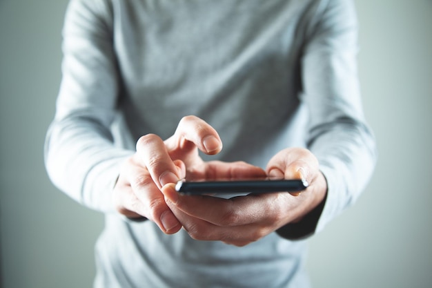 Businessman using smartphone on isolated gray background