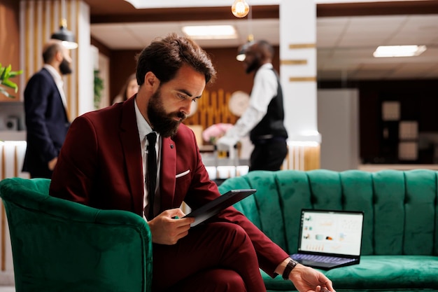 Businessman using tablet in hotel lobby