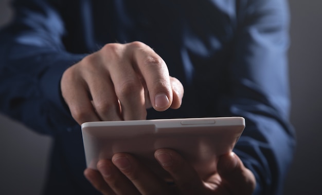 Businessman using white digital tablet.