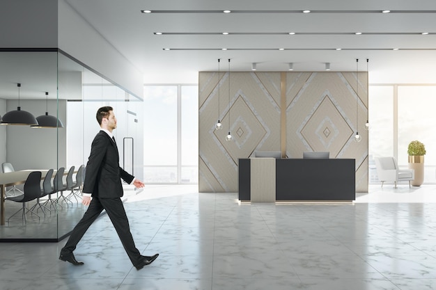 Businessman walking in luxury office lobby with reception