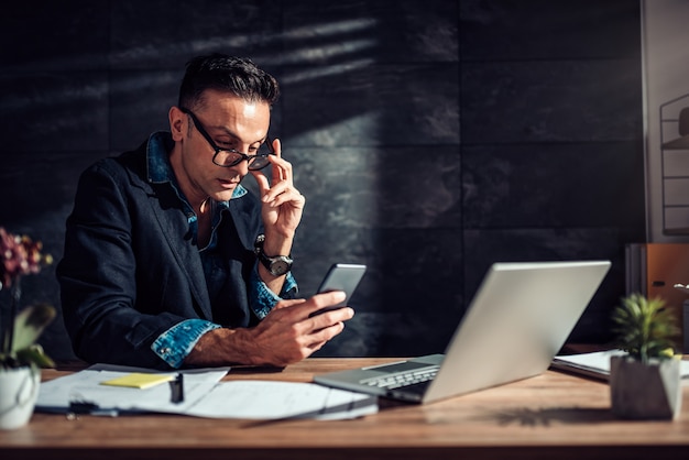 Businessman wearing eyeglasses using smart phone