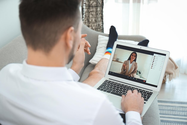 Businessman wearing shirt and underwear during video call at home back view