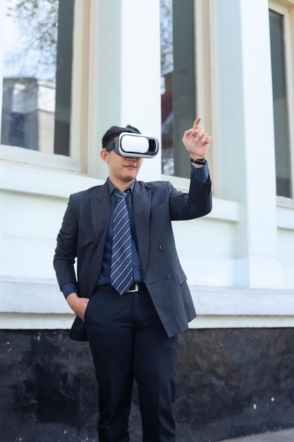 businessman wearing suit and VR glasses outside the office, having online simulation