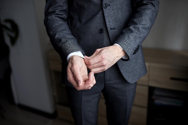 Businessman wears a jacket,male hands closeup,groom getting ready in the morning before wedding ceremony