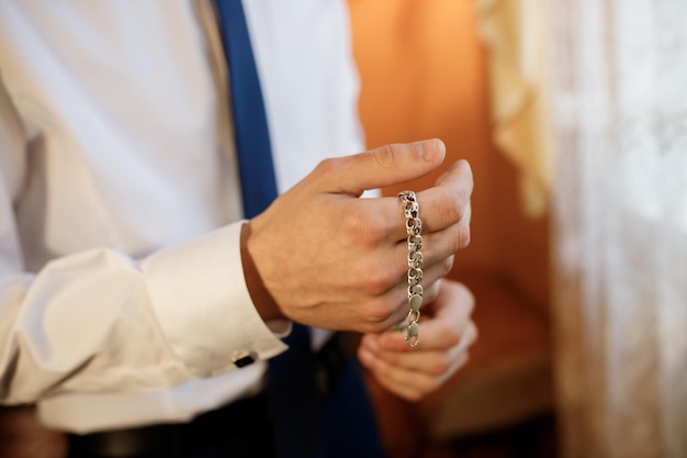 Businessman in white shirt putting bracelet on hand Man fashion