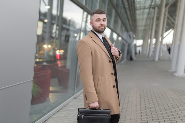 Businessman with a beard in a black jacket and coat