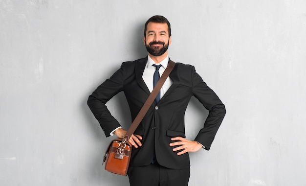 Businessman with beard posing with arms at hip and laughing looking to the front