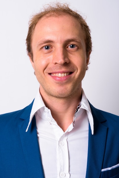 businessman with blond hair wearing blue suit against white space