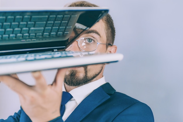 Businessman with a blue jacket on a gray background with a laptop in his hands