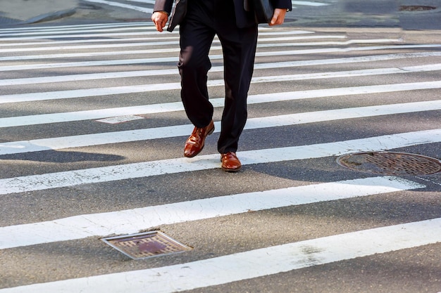 A businessman with a briefcase in a hurry to cross the road