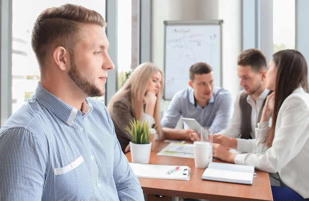 Businessman with colleagues in the background in office