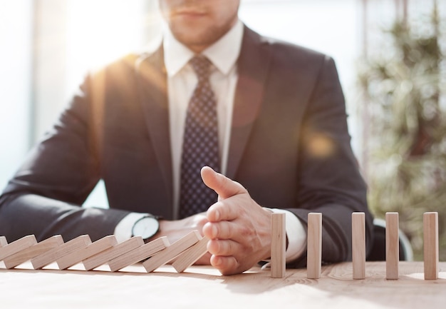 Photo businessman with dominoes in the office concept business risk