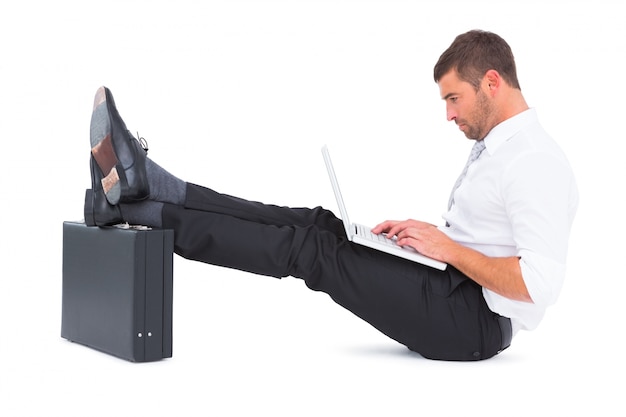 Businessman with feet up on briefcase