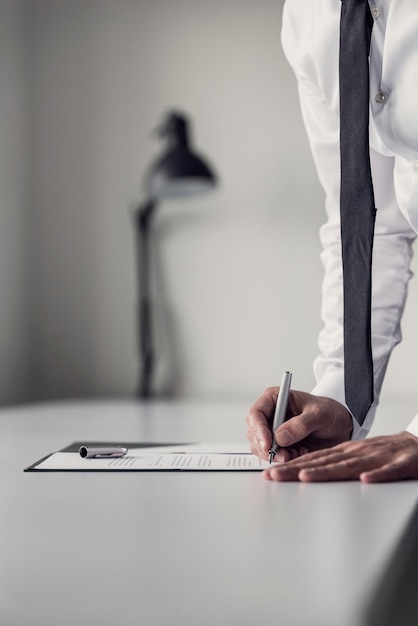 Businessman with fountain pen ready to put a signature on document