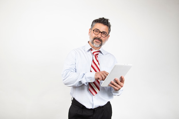 Businessman with glasses is using a digital tablet and smiling, isolated on white background