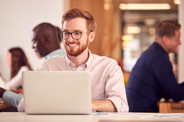 Businessman With Laptop Working On Table In Office Coffee Shop