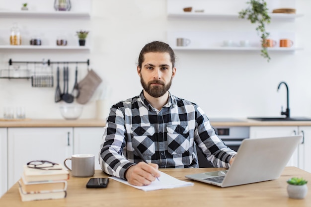 Businessman with pen making notes on draft of paper document