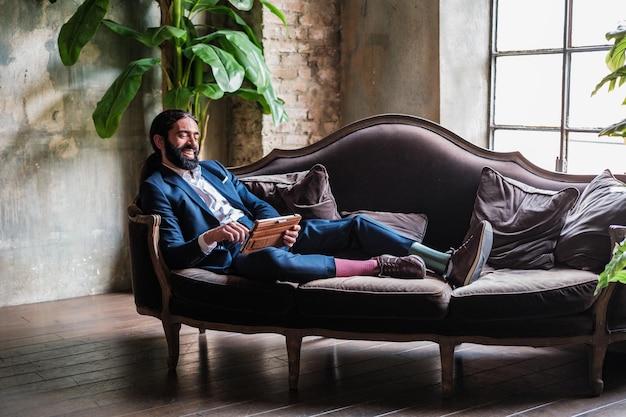 Businessman with prosthetic leg taking a break and enjoying with digital screens