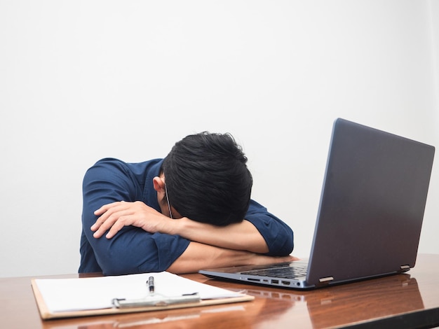 Businessman work hard and feels tried at working table white background