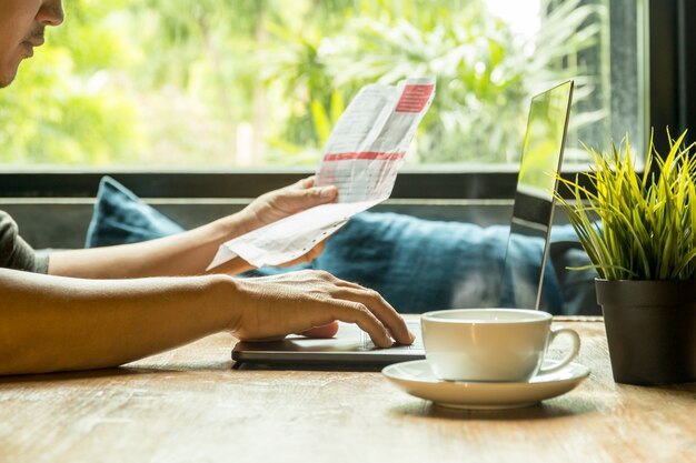 Businessman work on laptop checking invoice with coffee on wooden table