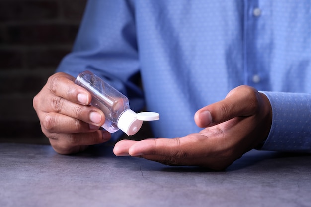 Businessman work in office room using hand sanitizer.