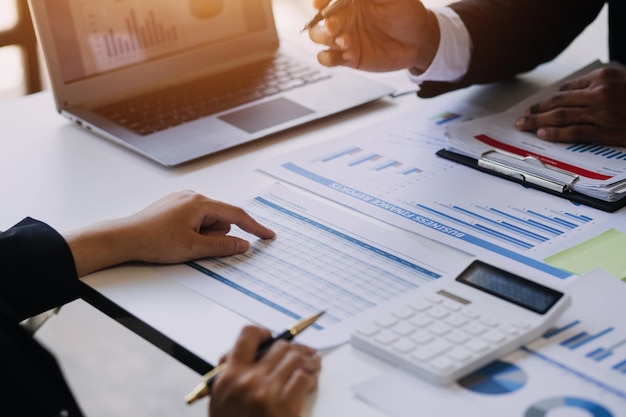 Businessman working on desk office with using a calculator to calculate the numbers finance accounting concept