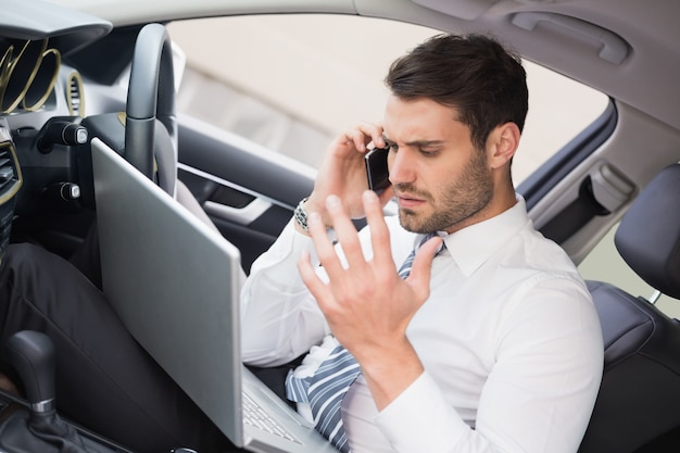 Businessman working in the drivers seat