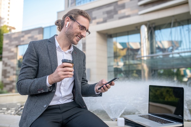 Businessman working on laptop outside the building