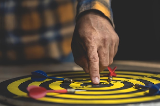 Businessman working in the office and point in the center of yellow dartboard Goal and success for business concept