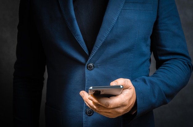 Businessman working using mobile phones with customers and plan business strategies working concepts using technology in most efficient way Closeup of businessman using cell phone