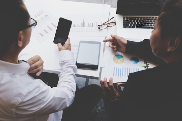 Businessman working with document, smartphone and digital tablet at office