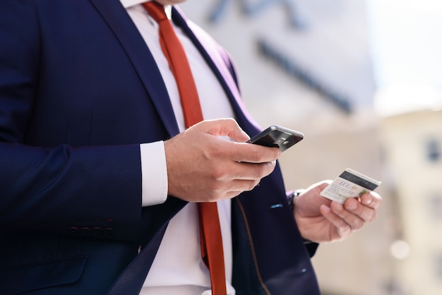 Businessman works with credit card and telephone