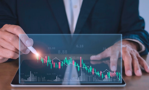 Businessman writing analyze graph for trade stock market on tabl