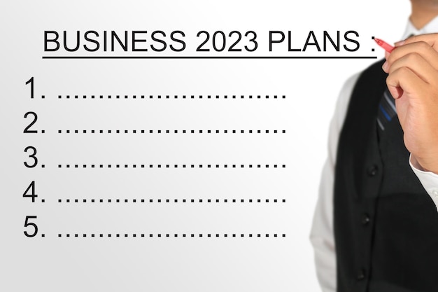 businessman writing business 2023 plans background