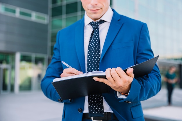 Businessman writing in folder