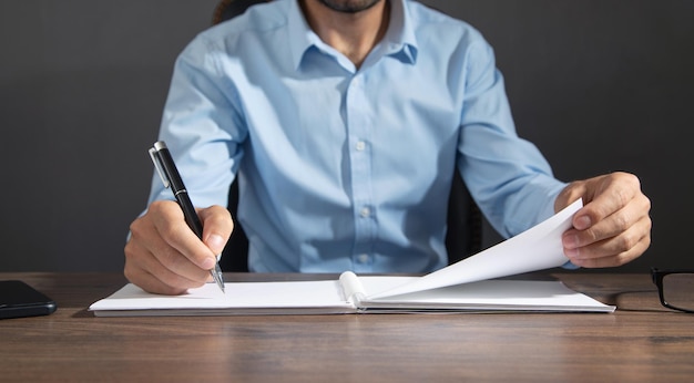 Businessman writing on a notepad in office