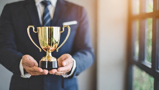 Businessmans hand holds leadership trophy symbolizing success and achievement