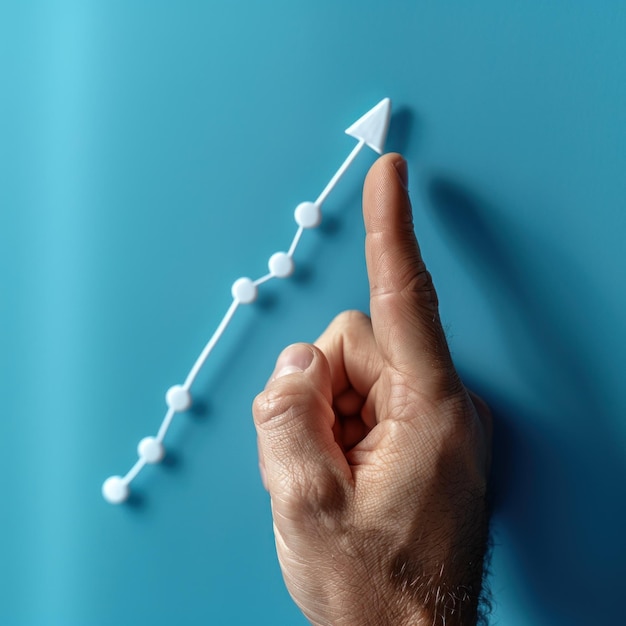 Photo businessmans hand points at a graph line growing upwards with a white arrow on a blue background