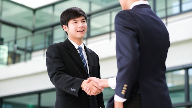 Businessmans handshake. Successful businessmen handshaking after good deal. Business partnership meeting concept.