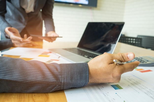 Businessmen are analyzing data with laptops and tablets