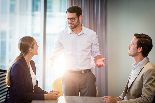 Businessmen and businesswoman interacting at their desk