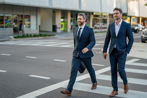 Businessmen couple walking across the crosswalk on american city street outdoor cheerful middle east