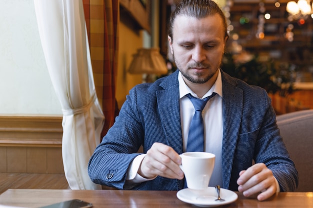 Businessmen drinking a coffee in the cafe bar  during coffe break.