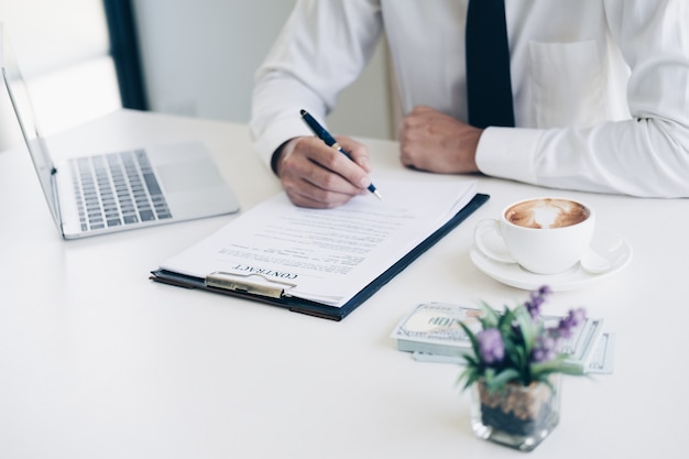 Businessmen holding pen to write business document and contract sheet