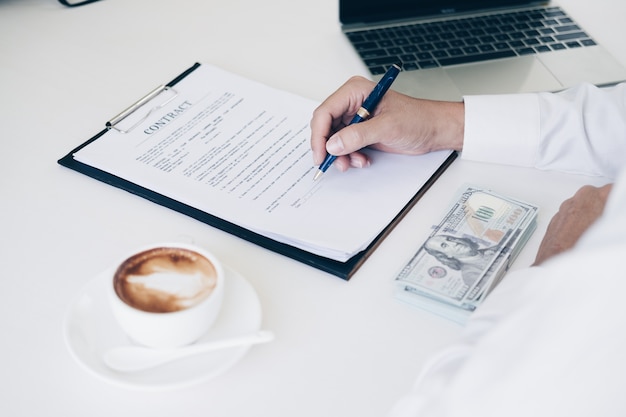 Businessmen holding pen to write business document and contract sheet