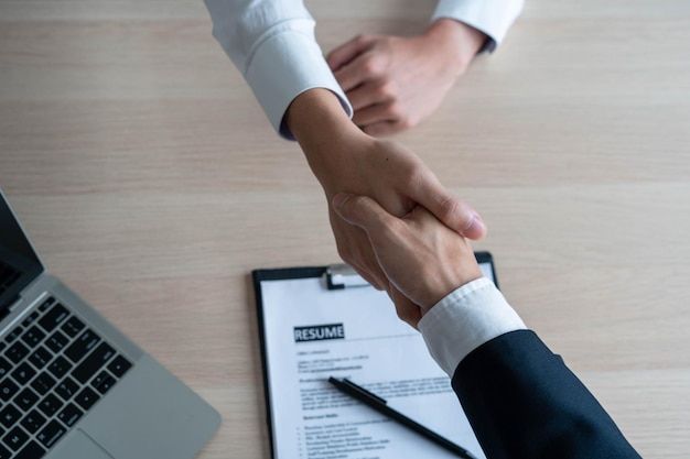 Businessmen and job seekers shake hands after agreeing to accept a job and approve it as an employee in the company Or a joint venture agreement between the two businessmen