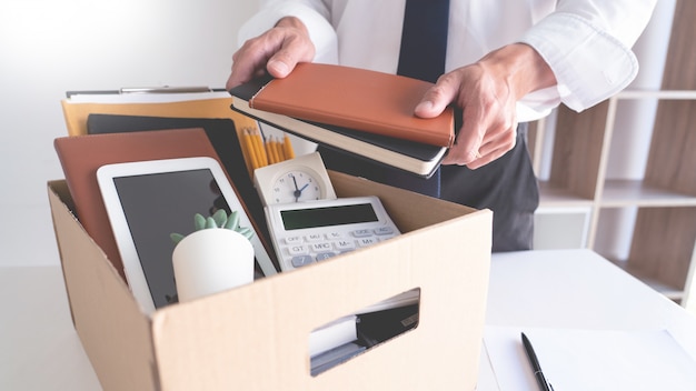 Businessmen keeping his things on a carton box