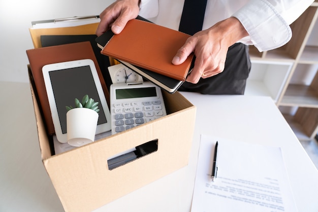 Businessmen keeping his things on a carton box