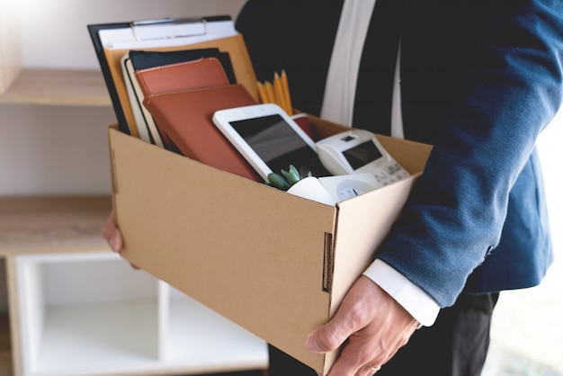 Businessmen keeping his things on a carton box