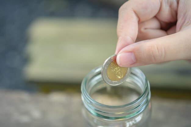 Businessmen Put the coin in a glass jar To save money, save money on investments, 